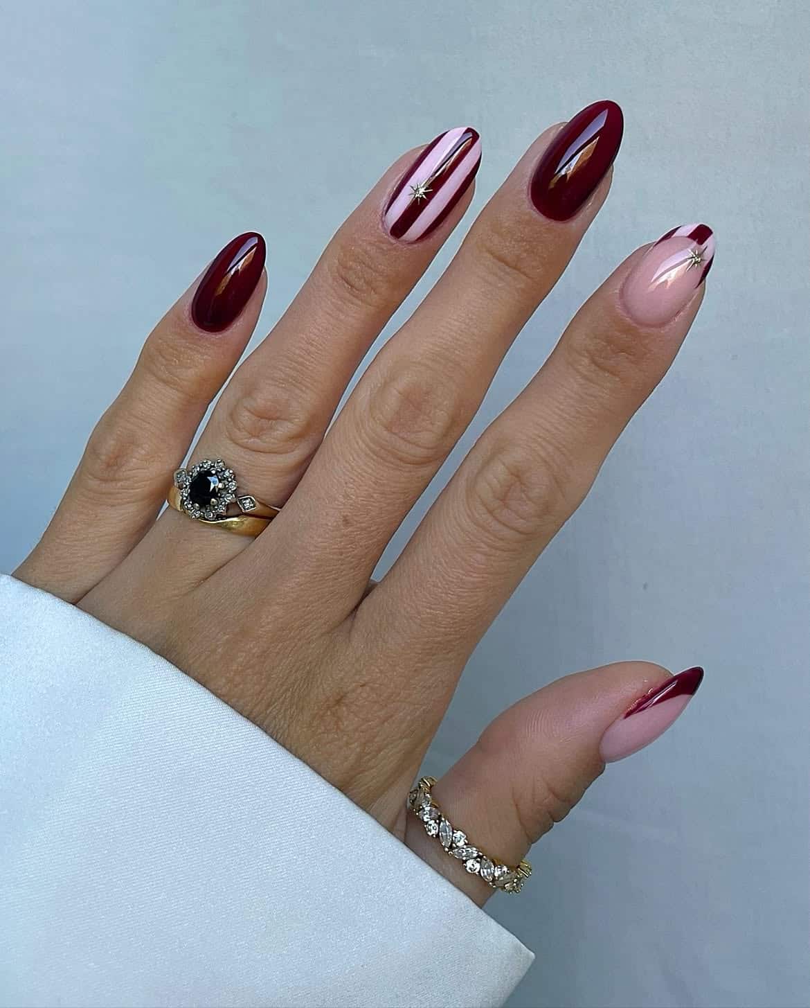 Burgundy nails with gold stripes, almond shape