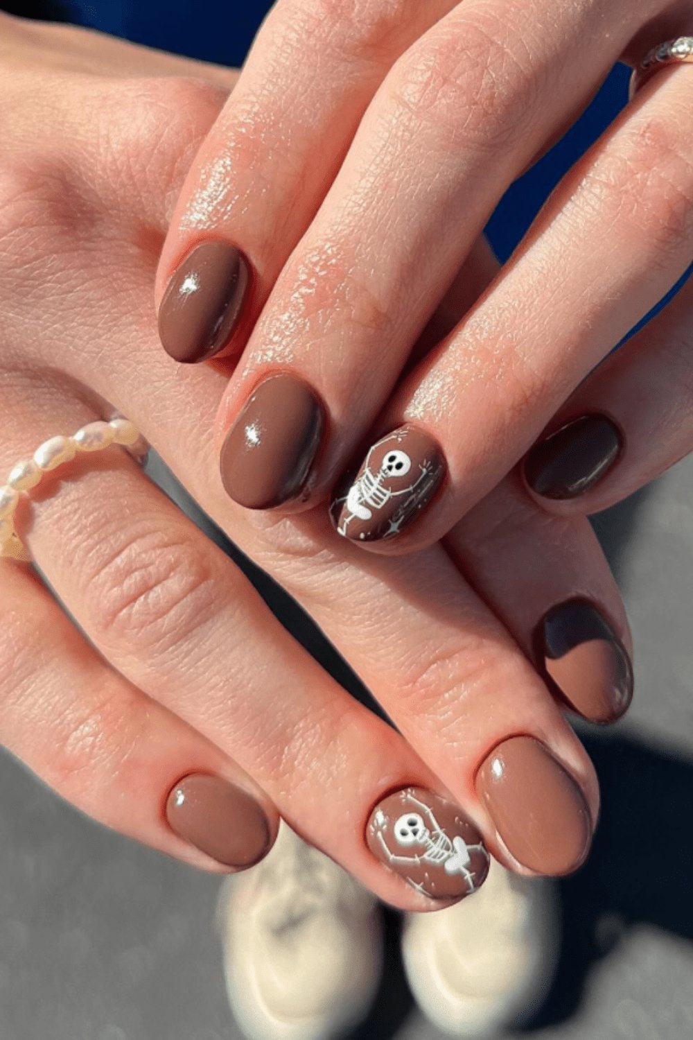 Glossy brown nails with skeleton art