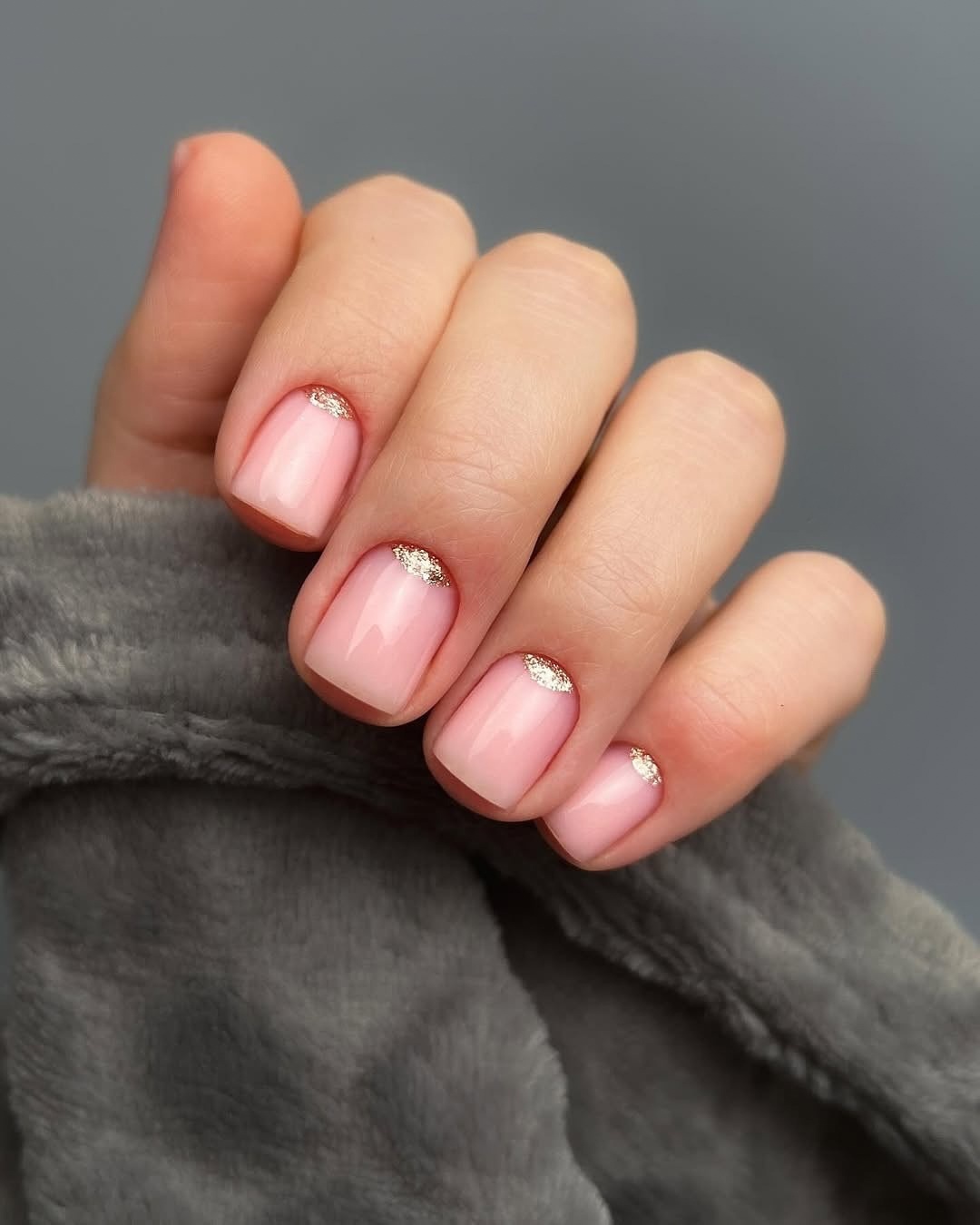 Pink square nails with glitter half-moon accents, perfect for elegant and festive looks.
