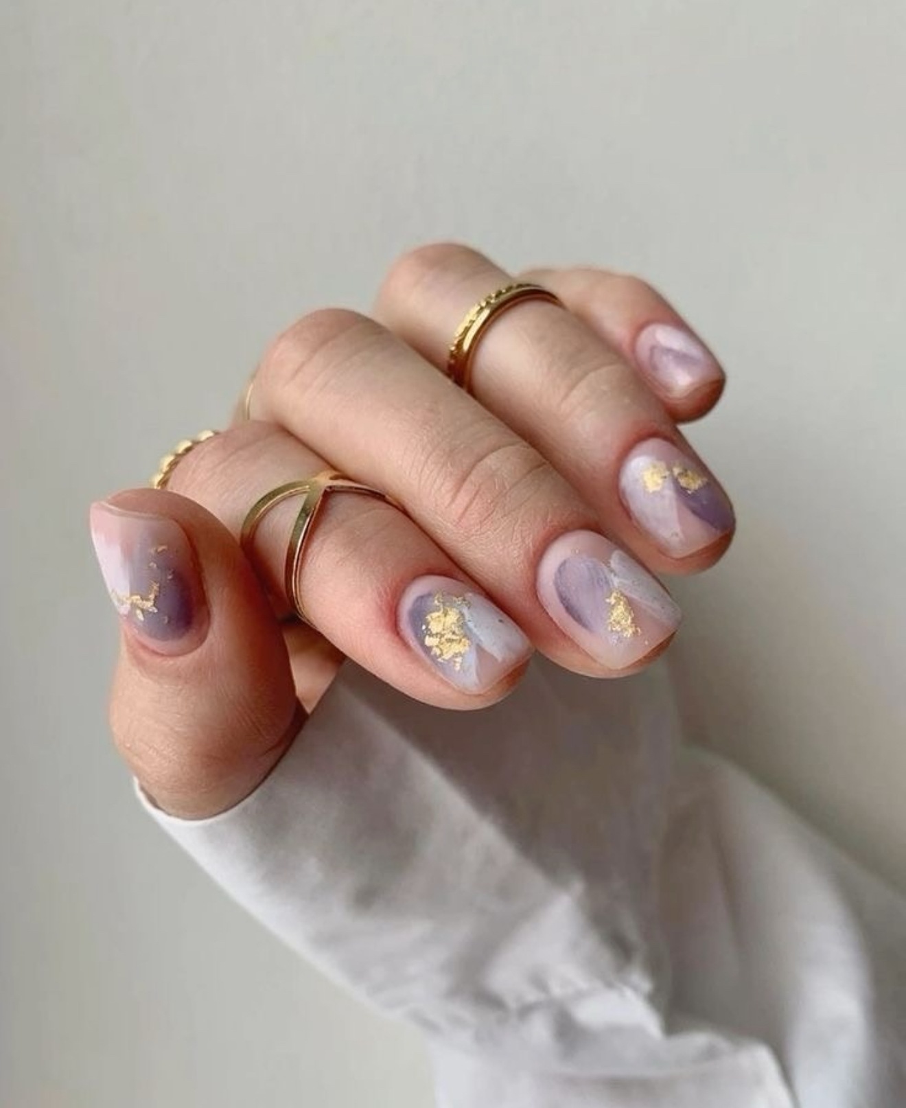 Lavender marble nails with gold accents, suitable for elegant and artistic styles.