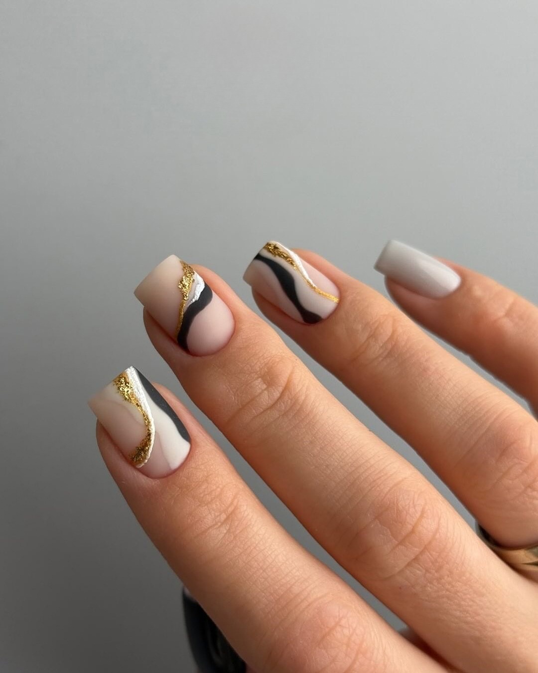 Geometric nail art with gold accents, perfect for chic and elegant styles.