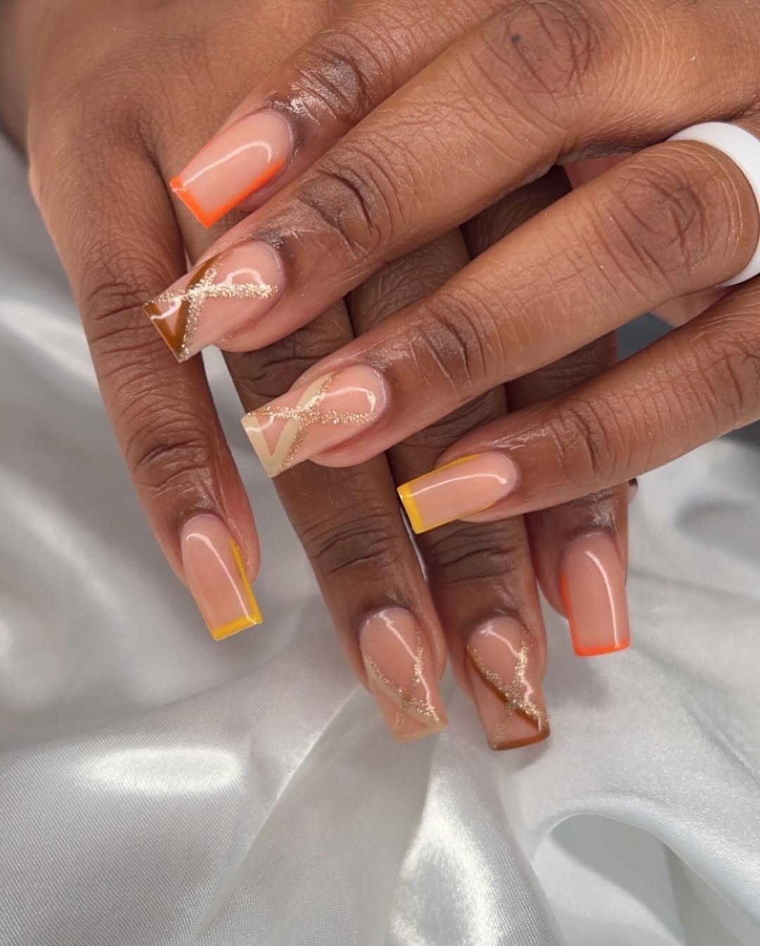 Colorful French tip nails with geometric accents, perfect for bold and modern styles.