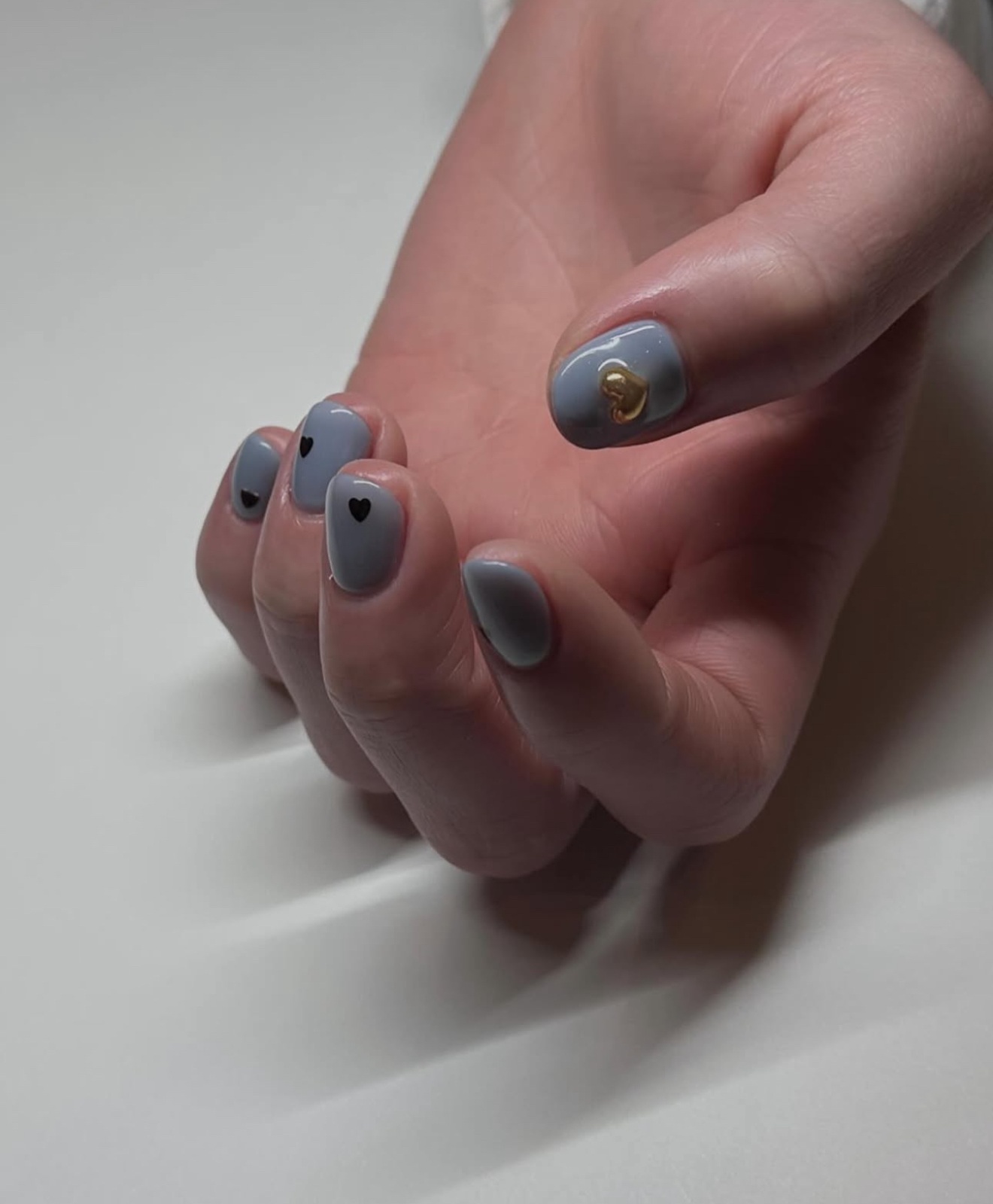 Gray nails with heart and gold accents, ideal for sophisticated and playful styles.