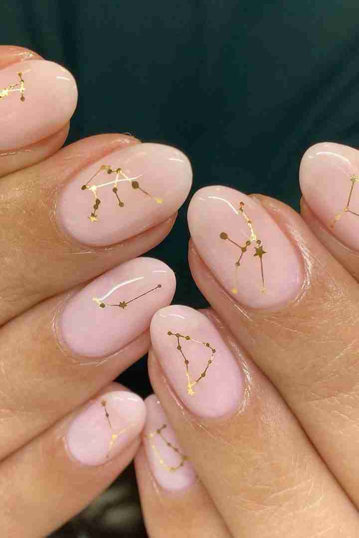 Pink nails with gold constellation art