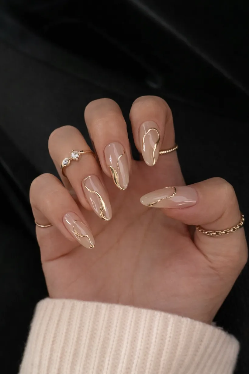Nude nails with gold swirl accents