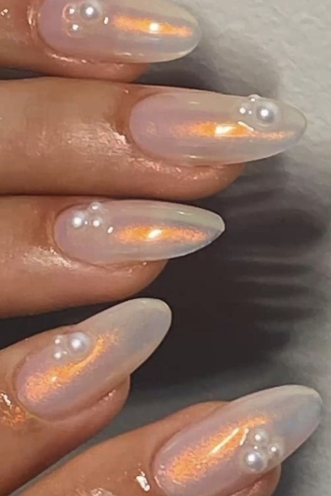 Opal nails with pearl accents and almond shape