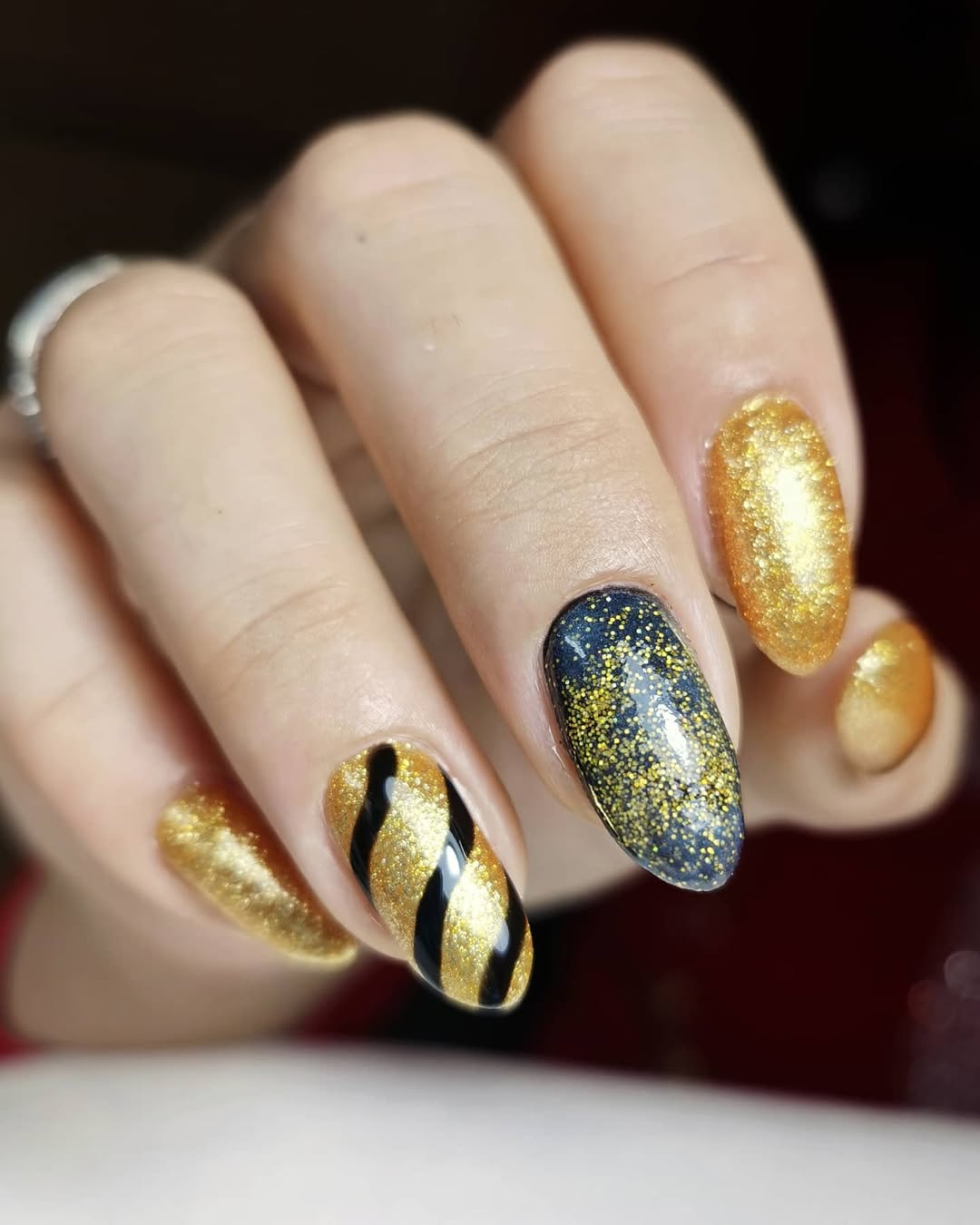 Almond nails with gold and black stripes
