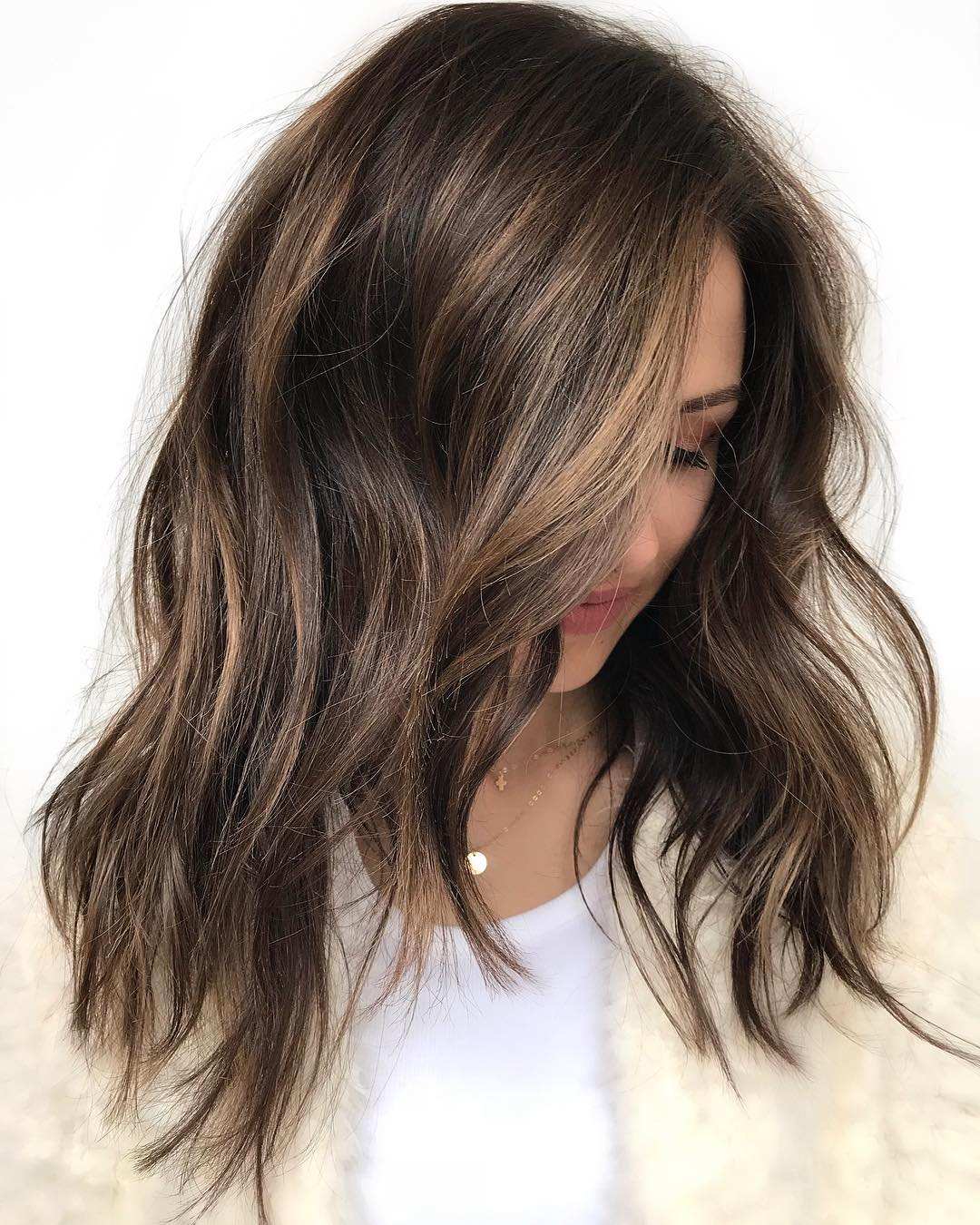 Medium-length chocolate brown hair with caramel highlights