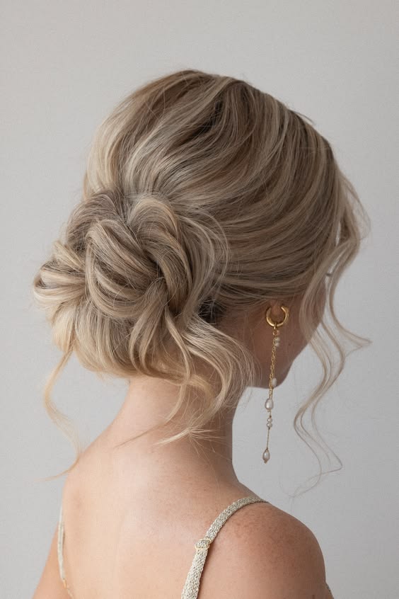 Delicate chignon with loose waves and face-framing pieces