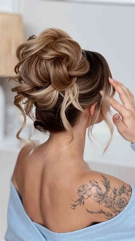 Voluminous updo with blonde highlights and loose curls