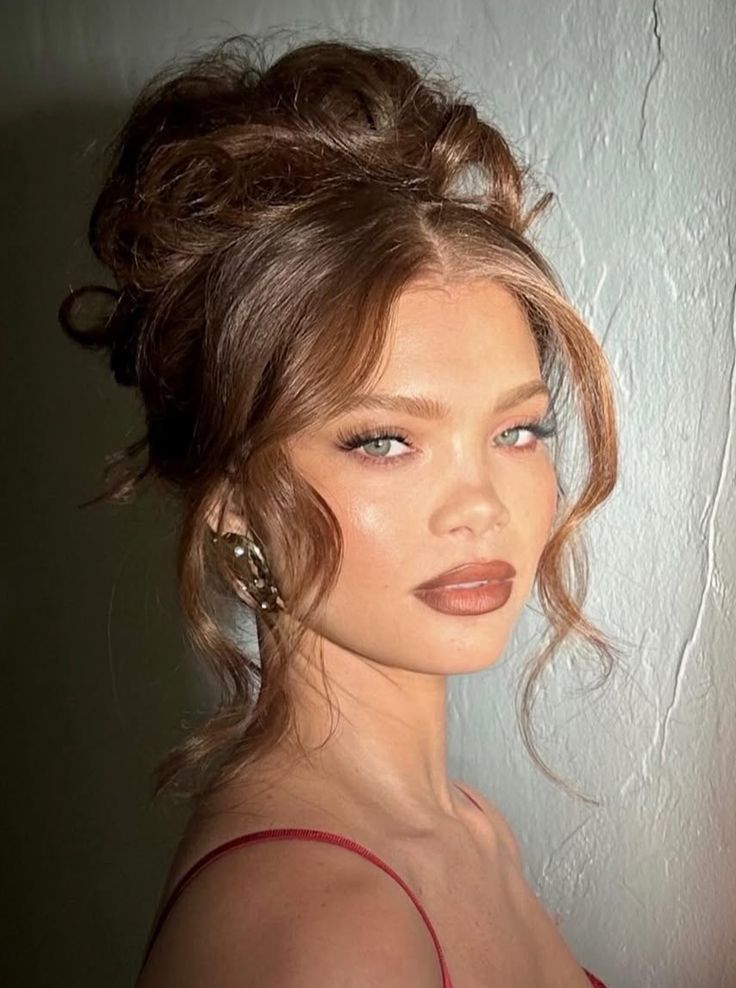 Voluminous curly updo with soft tendrils