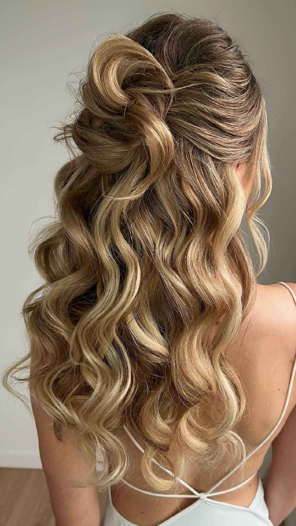 Soft waves with half-up twist in blonde hair