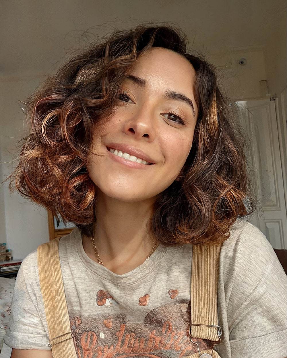 Curly bob with subtle highlights for warmth