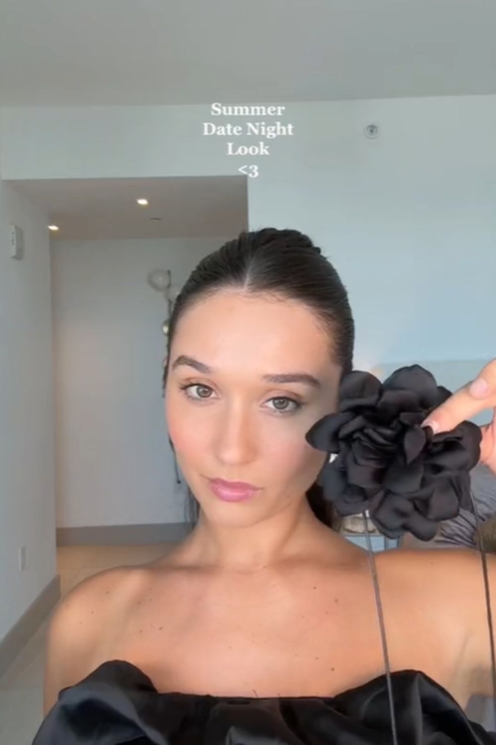 Sleek ponytail with black flower accent
