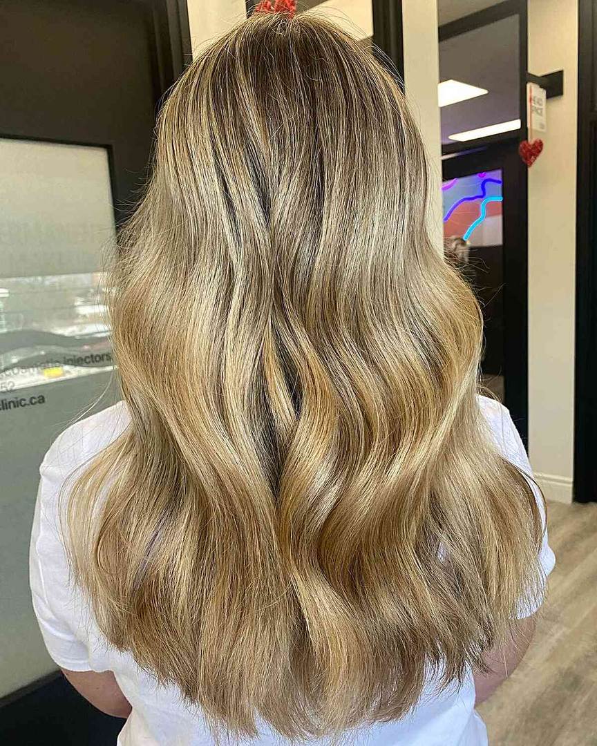 Long wavy hair with sun-kissed honey blonde highlights