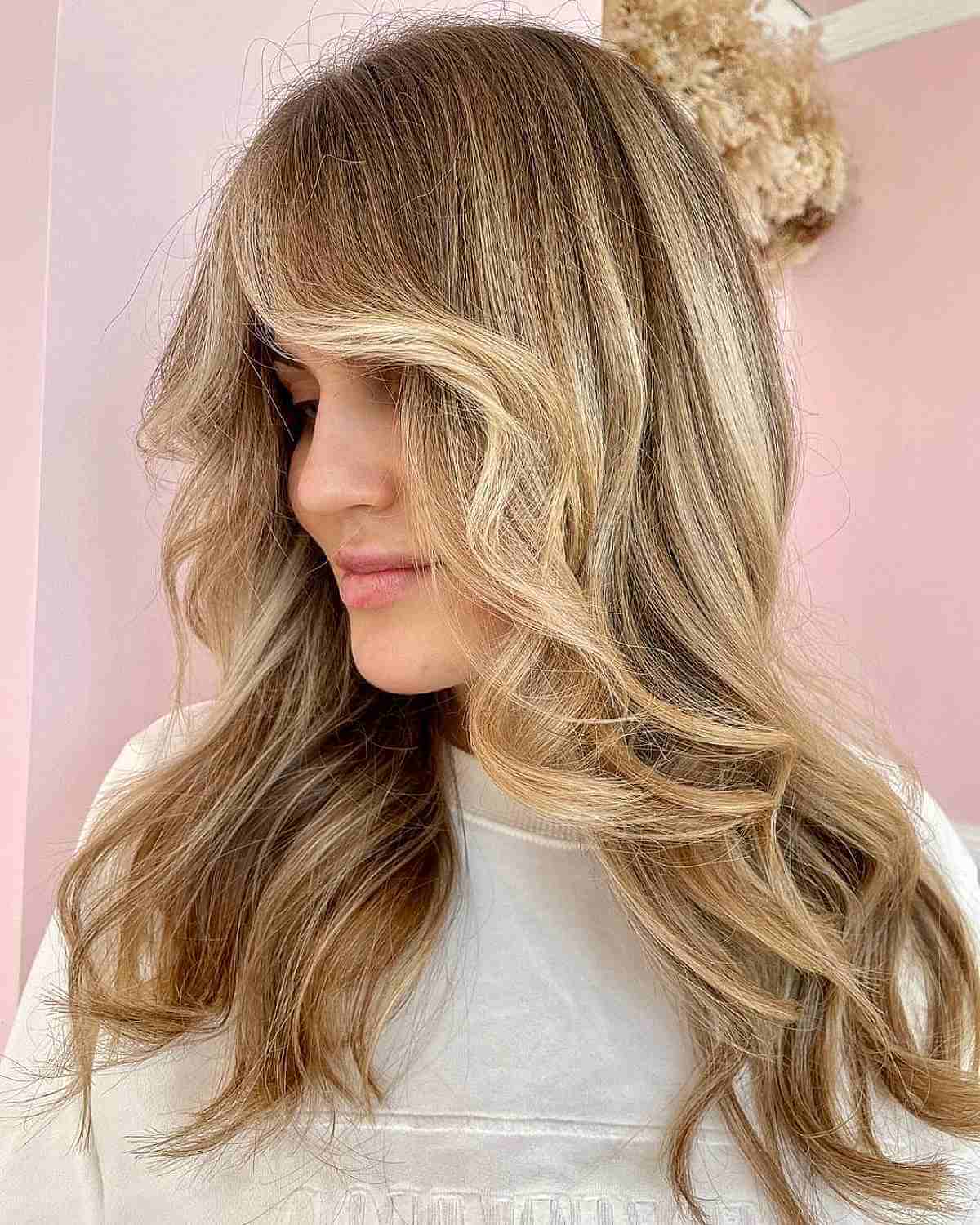 Wavy hair with honey blonde highlights and face-framing layers