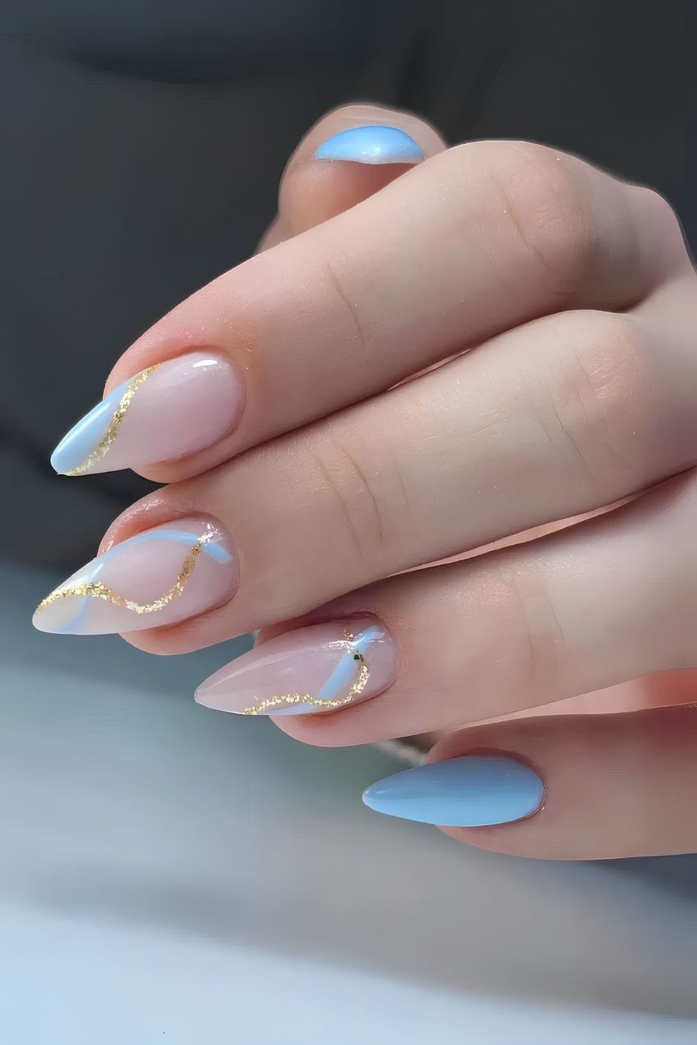 Gold-accented light blue nails with almond shape
