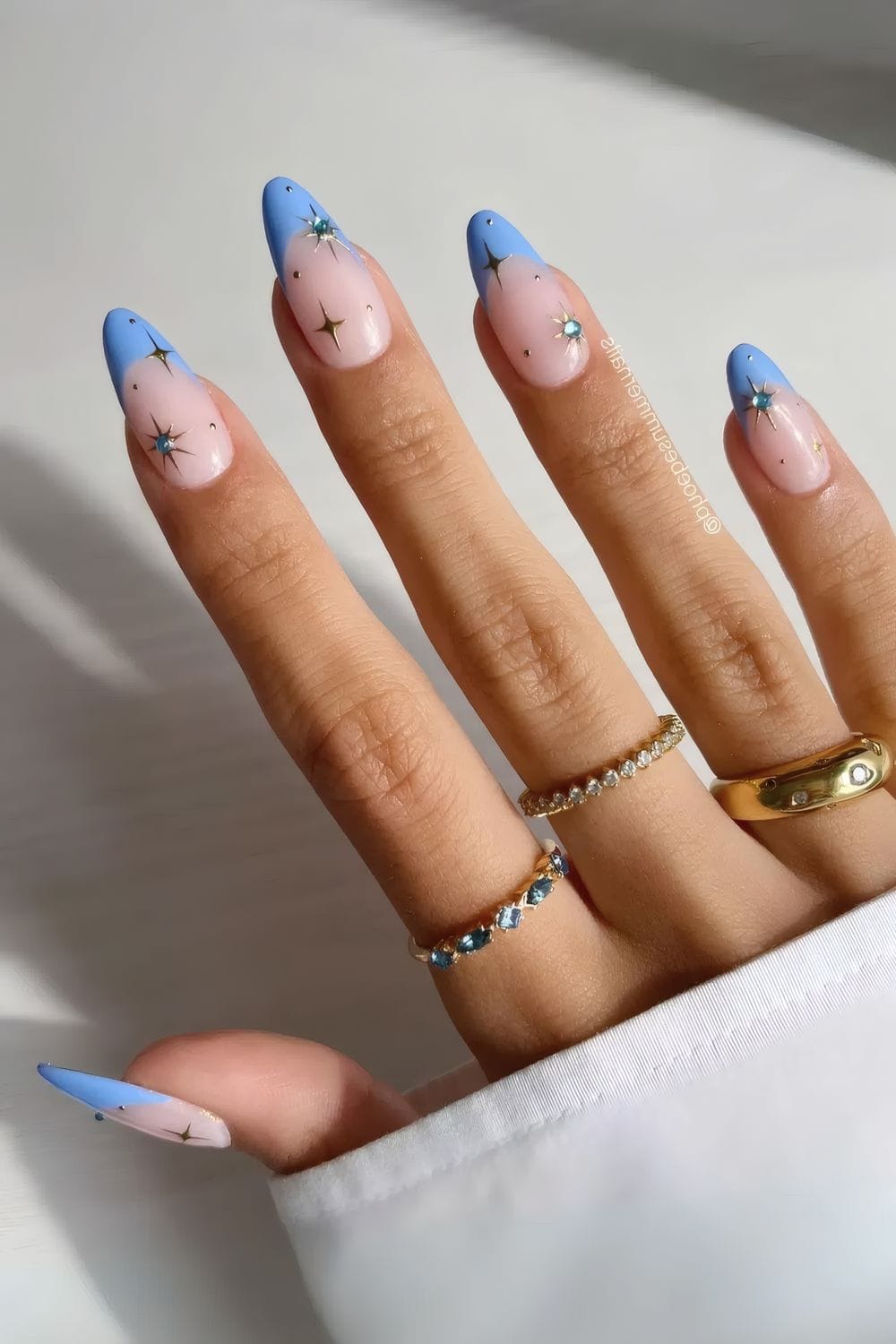 Stellar blue tipped almond nails with stars