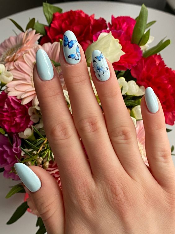 Pastel blue nails with butterfly accents