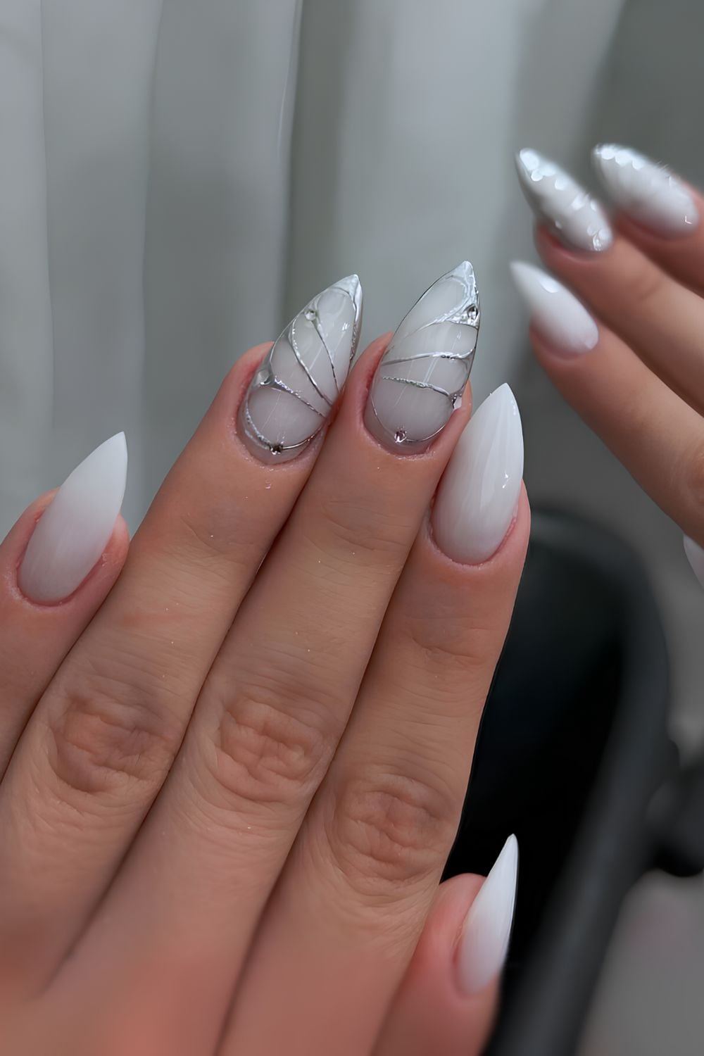 Milky stiletto nails, silver accents, bold and chic