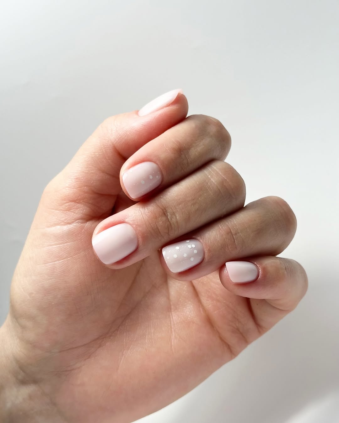 Short milky nails with polka dots, playful and stylish