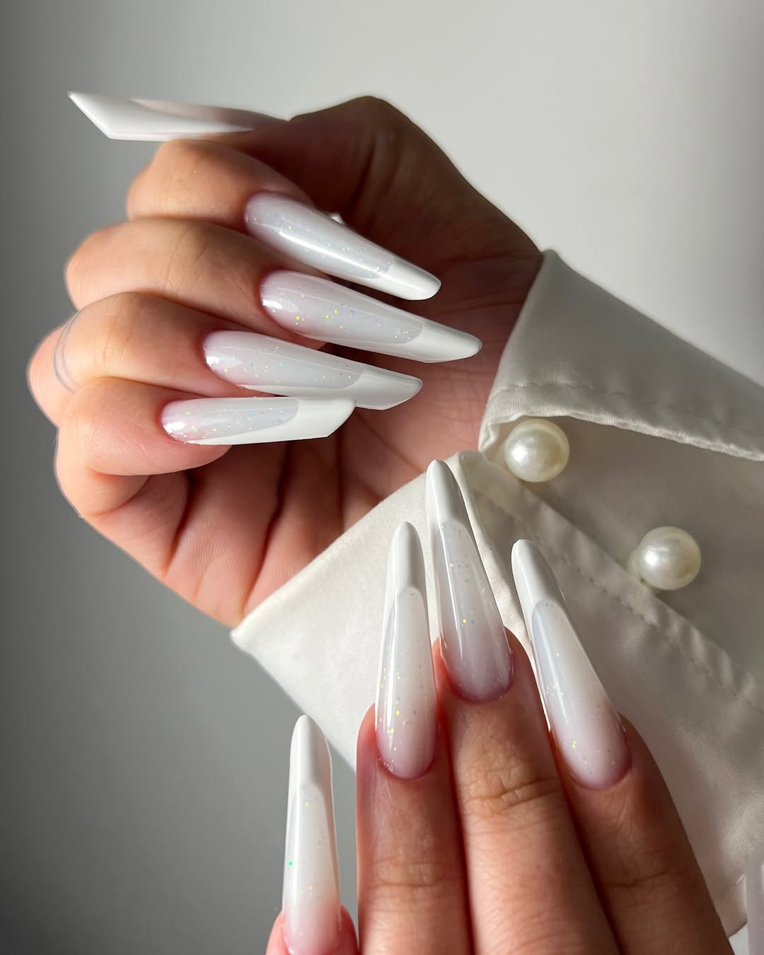 Milky stiletto nails, glitter tips, bold and glamorous