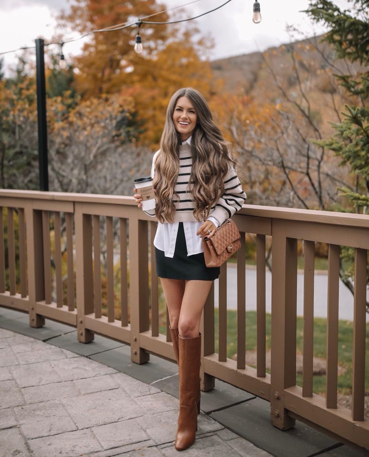 Striped sweater, white shirt, and black mini skirt with boots
