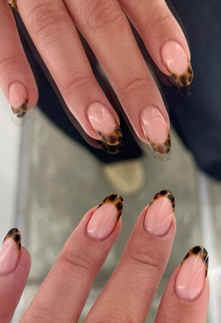 Elegant tortoiseshell French tips on oval nails.