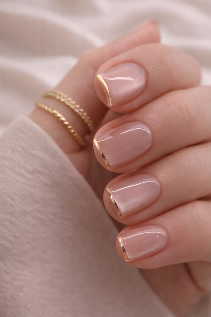 Nude nails with gold micro-French tips.