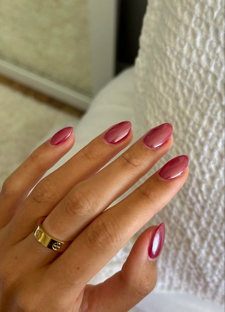Short oval nails with glossy mauve hue.