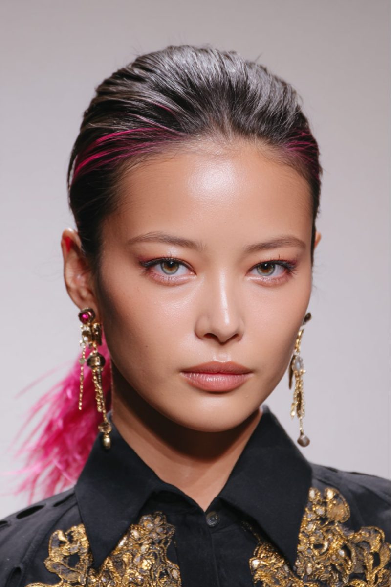 Vibrant pink accents on sleek, pulled-back hair