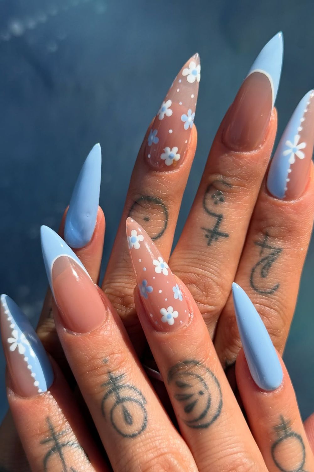 Blue and nude stiletto nails with daisy accents
