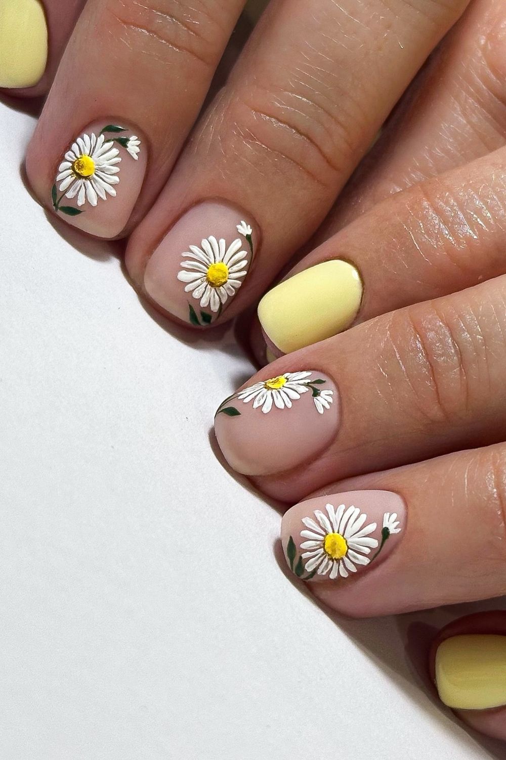 Yellow and nude nails with daisy designs