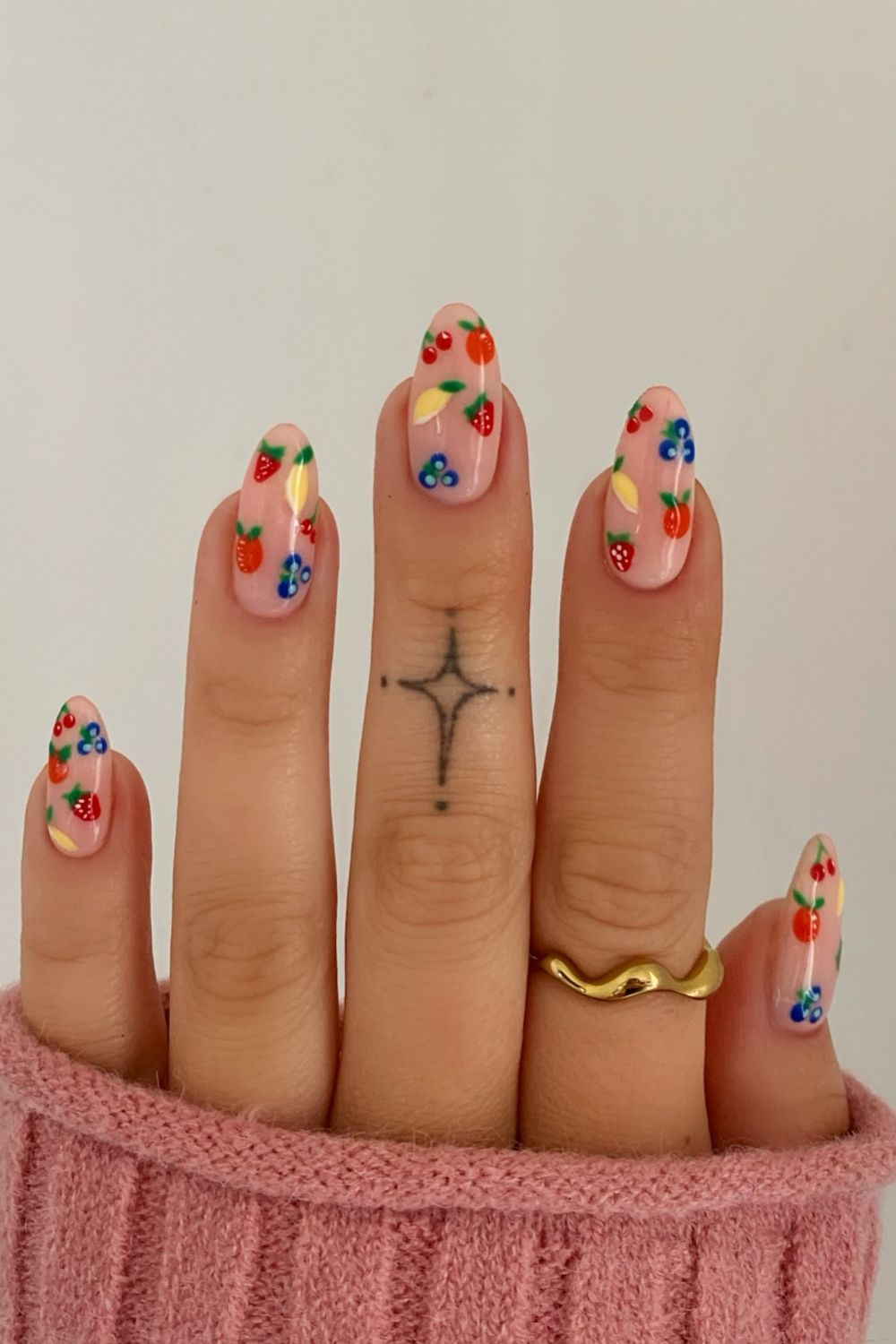 Colorful berry-themed almond nails with fruit designs, playful nail art