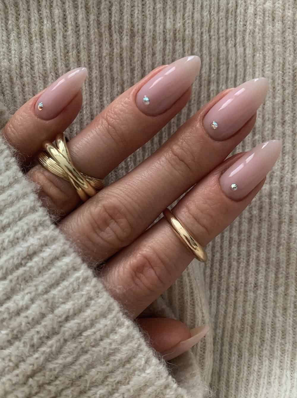 Glazed nude nails with rhinestone accents, almond shape, elegant and sophisticated.