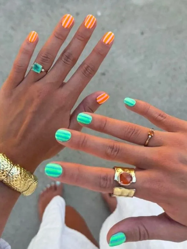 Colorful striped nails with orange and green, offering a fun, Pinterest-ready summer vibe.