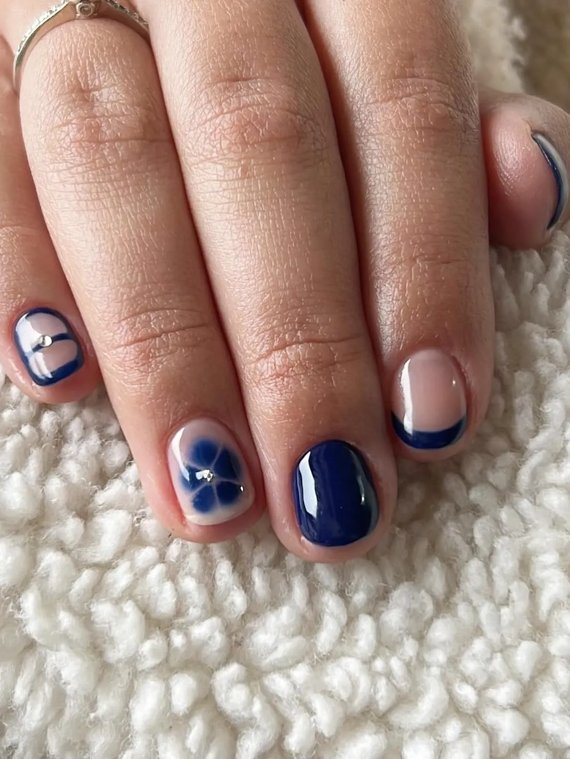 Deep blue nails with floral accents, blending classic style with Pinterest floral trends.