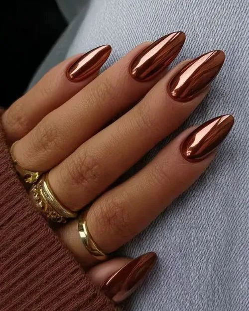 Metallic copper stiletto nails with a high-shine finish, reflecting bold Pinterest trends.