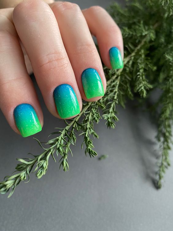 Green and blue gradient nails with tropical vibes.