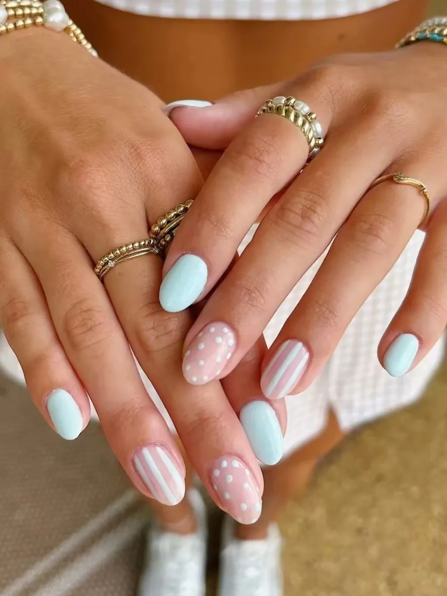 Pastel striped and dotted nails with playful elegance.
