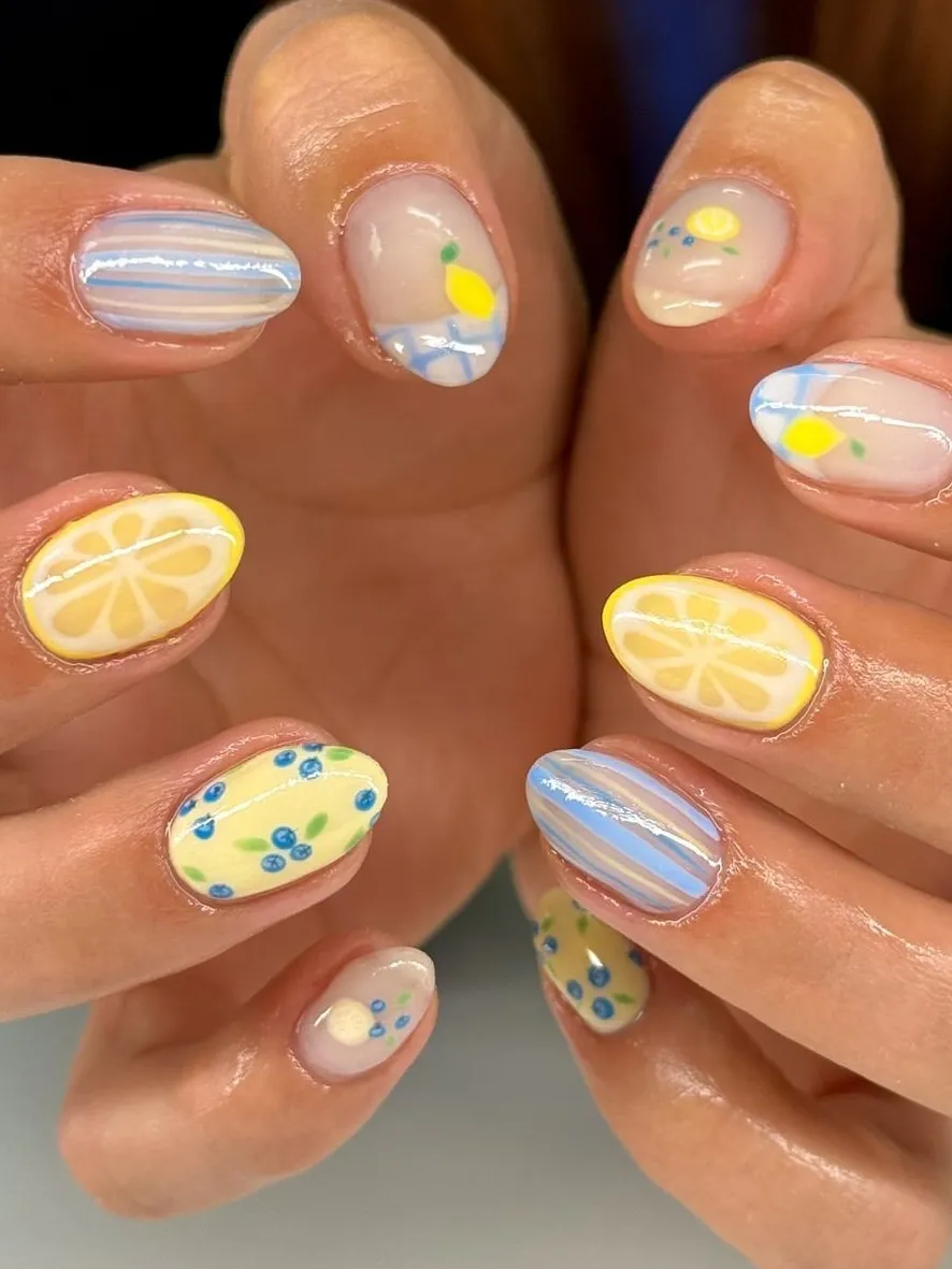 Colorful lemon-themed nails with playful designs.
