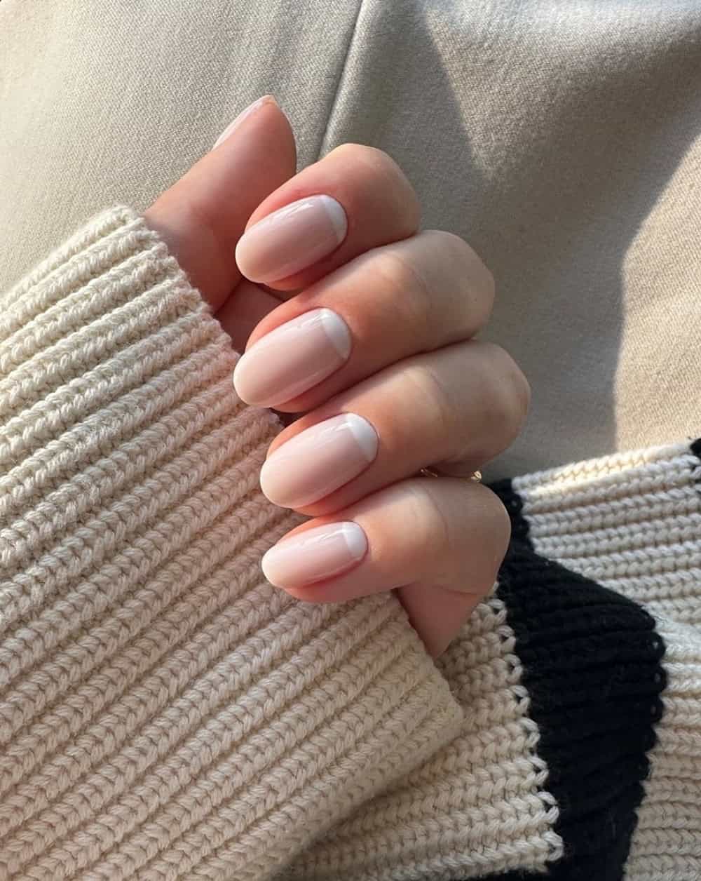 Soft pink almond nails with micro-French tips.