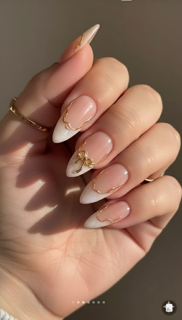 Gold accented French almond nails, elegant and luxurious.