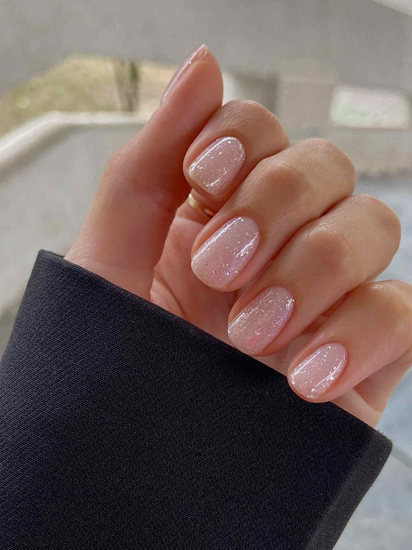 Glitter-infused nude nails with a glossy finish