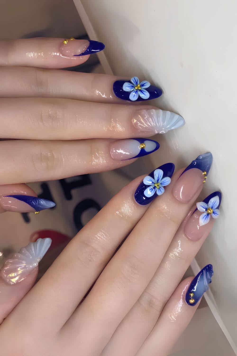 Navy nails with floral designs, creative and artistic.