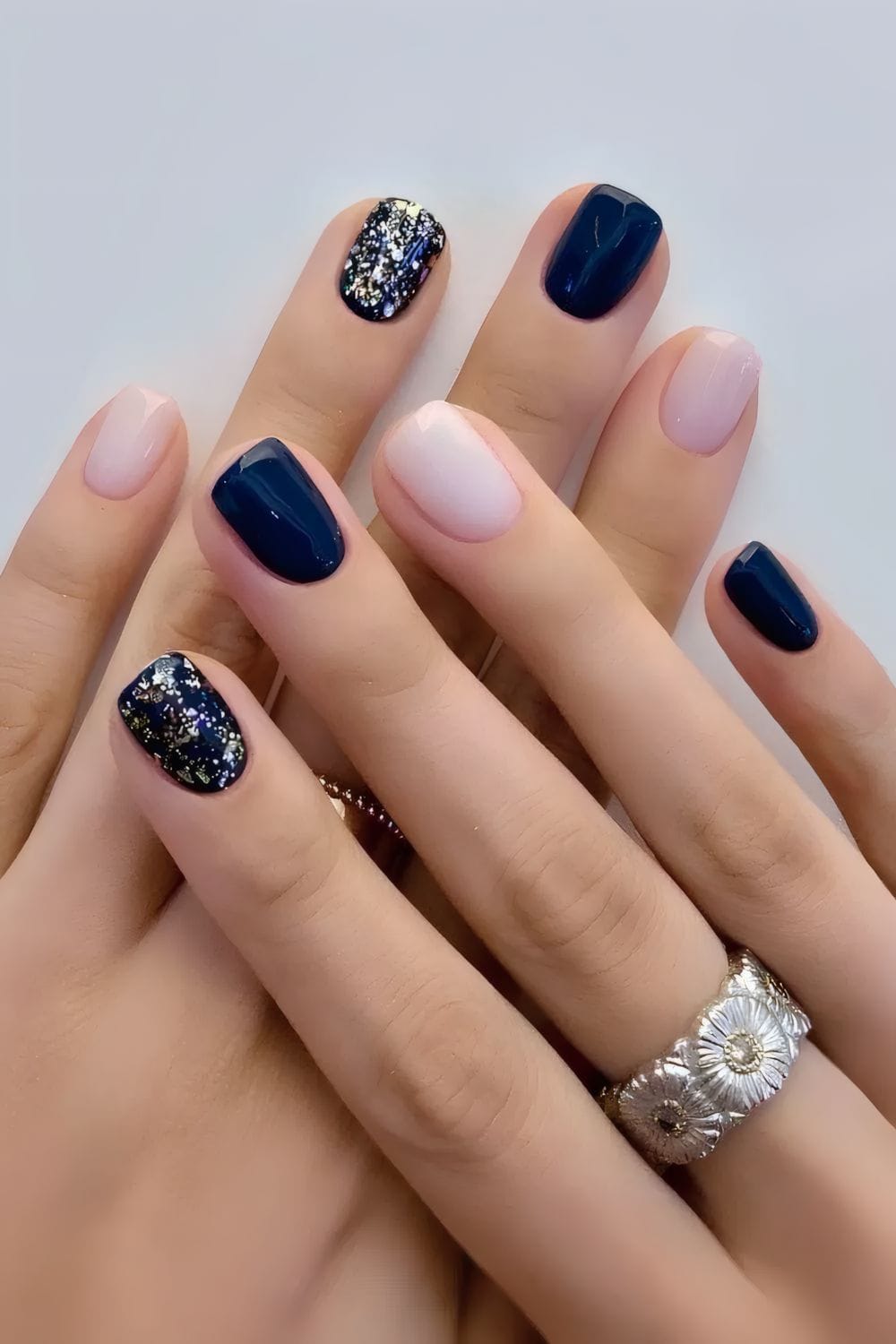 Navy and nude nails with glitter accents, elegant and playful.