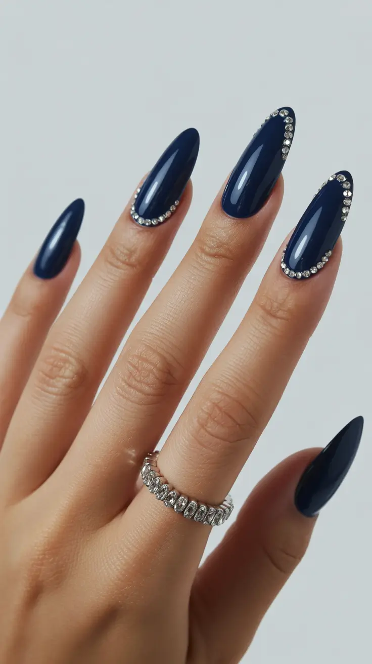 Navy nails embellished with rhinestones, luxurious and bold.