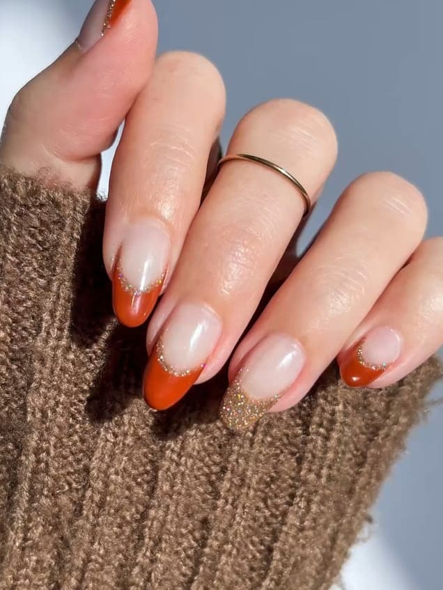 Orange French tips with glitter accent nail