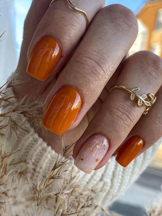 Earthy orange nails with gold accents and shimmer