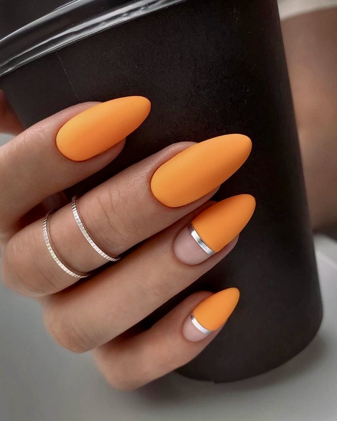 Matte orange nails with metallic accent